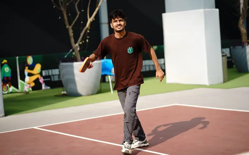 A young man playing pickleball outdoors, showcasing active lifestyle and fitness